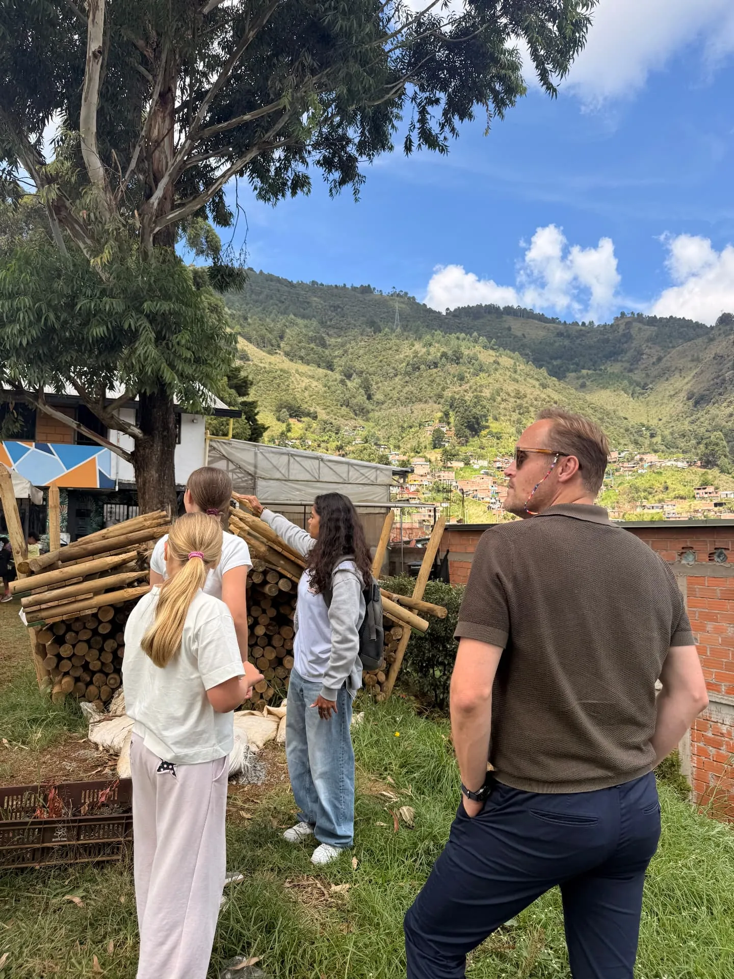 Our family looking out over the hillside neighbourhood beside stacked bamboo poles