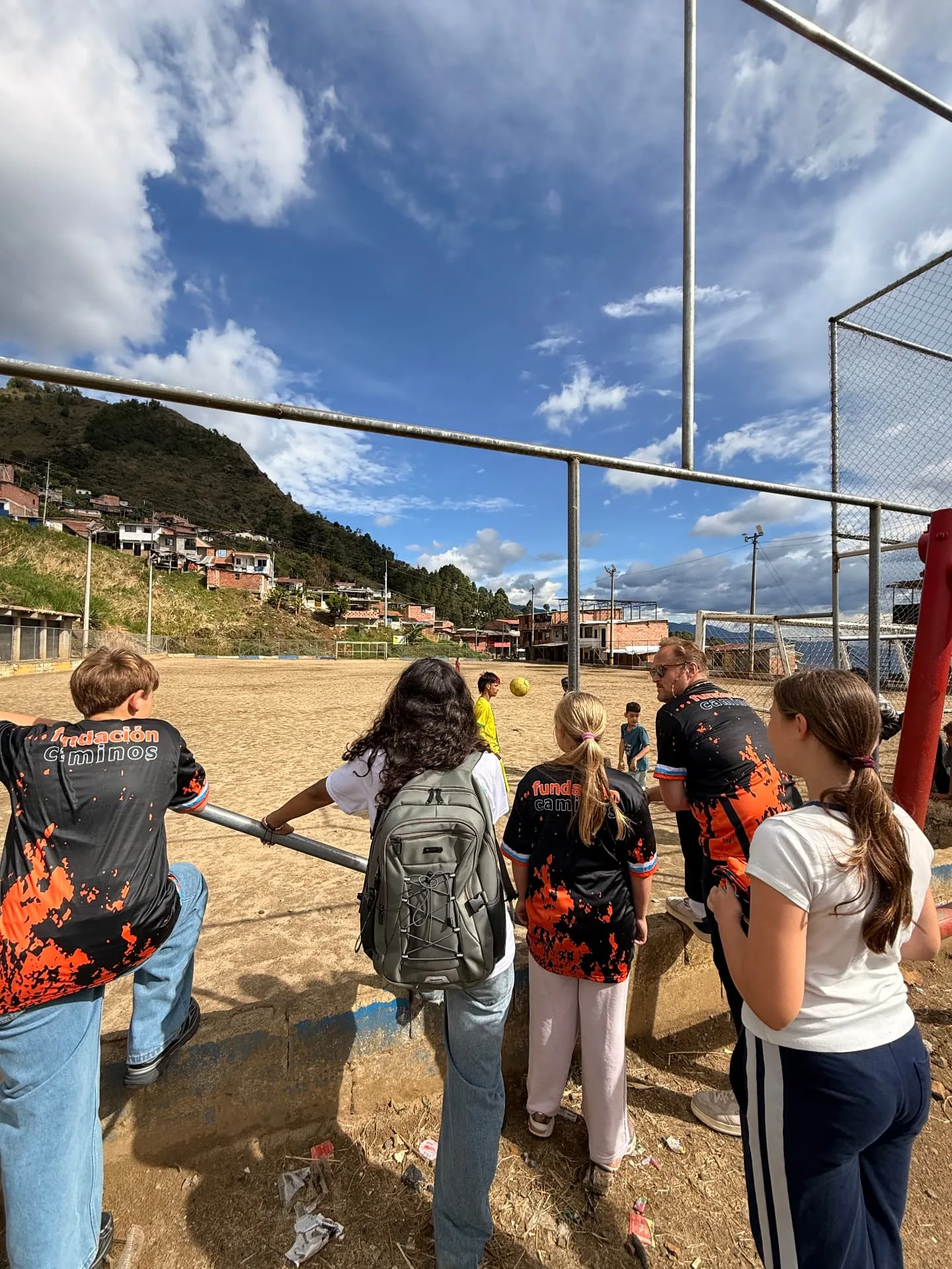 Watching a football match on the sand pitch above the hillside neighbourhood